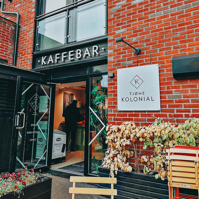 Fasaden til en kolonial og kaffebar med rød murstein.