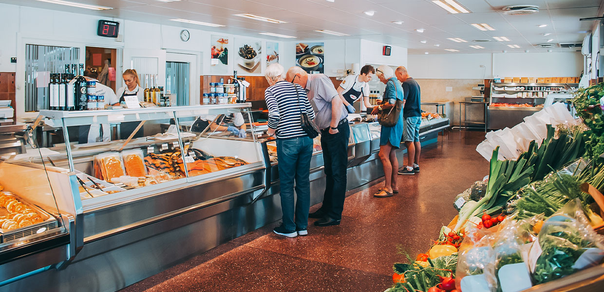 mennesker kjøper fisk på fiskebutikk