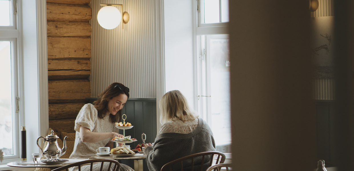 to personer sitter ved bord og spiser mat